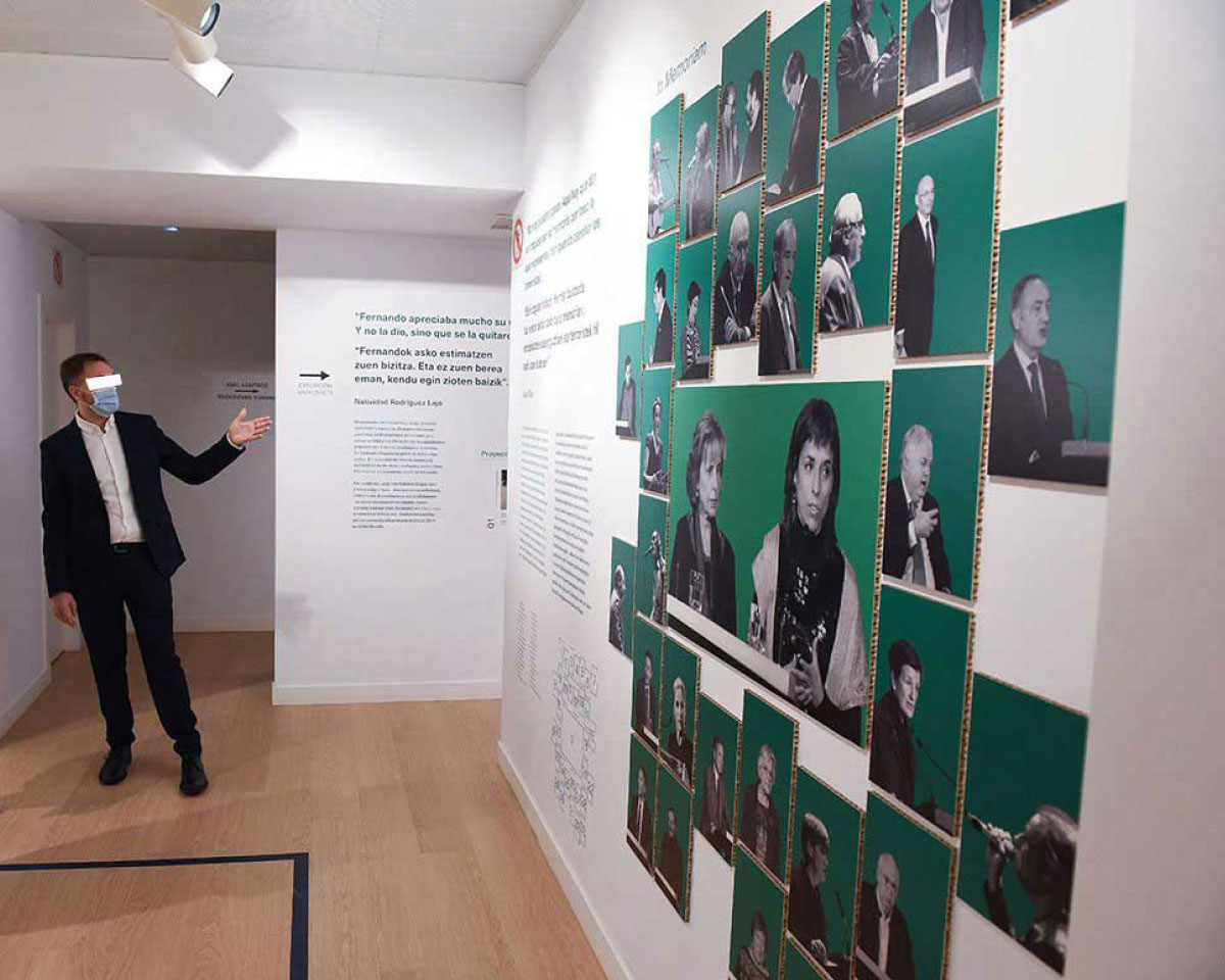 Asistentes a la inauguración de la exposición leyendo el texto de una pared.