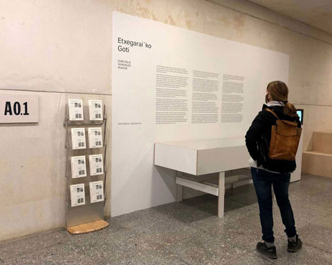 Fotografía de una mujer leyendo el texto en la pared de la exposición de González Placer.