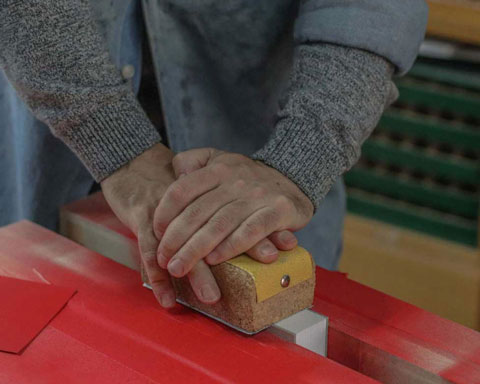 Zigor lijando un taco de tarjetas para después pintarlas con spray.